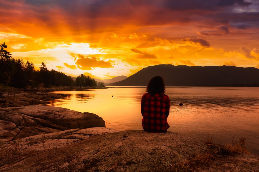 Stillness by the lake Person in silhouette sitting at lake